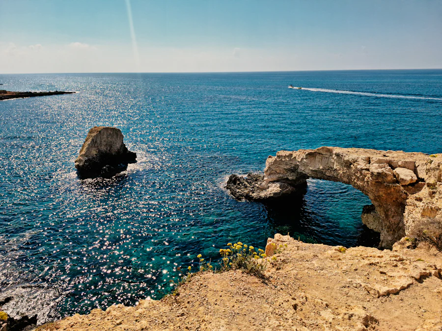 Natural limestone sea arch over clear turquoise water at Cape Greco, Cyprus
