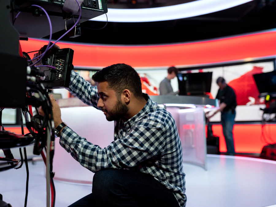Camera operator framing a shot inside a television news studio