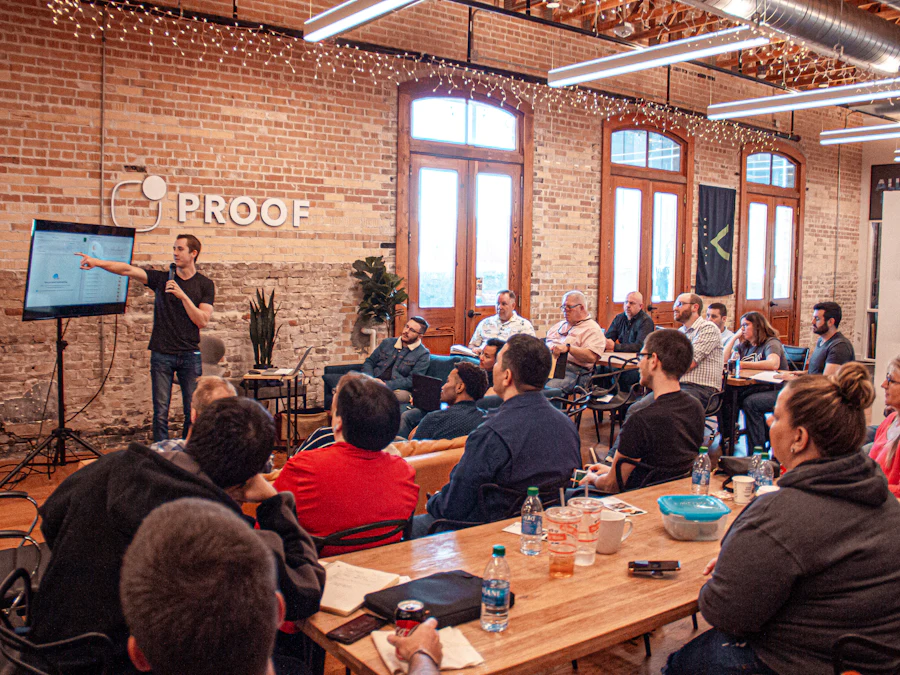 A trainer presenting to a seated group of participants in a brick-walled workshop room